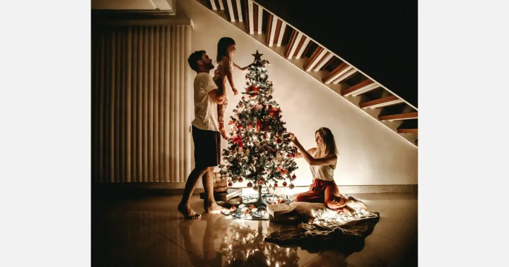 A young couple and their child decorating the T27 Christmas Tree for the holidays